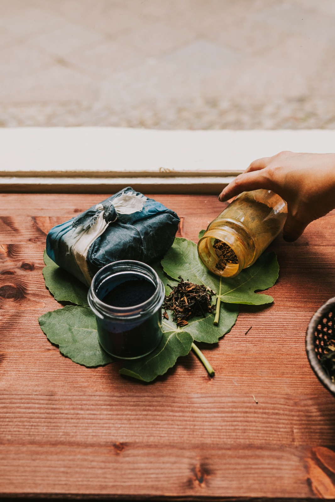 Yurika Saito's dye jars — indigo and tea waste on fig leaves