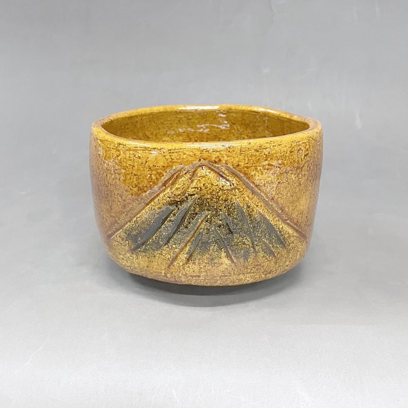 Mt. Fuji: an amber Raku tea bowl with Mt. Fuji carved into the wall