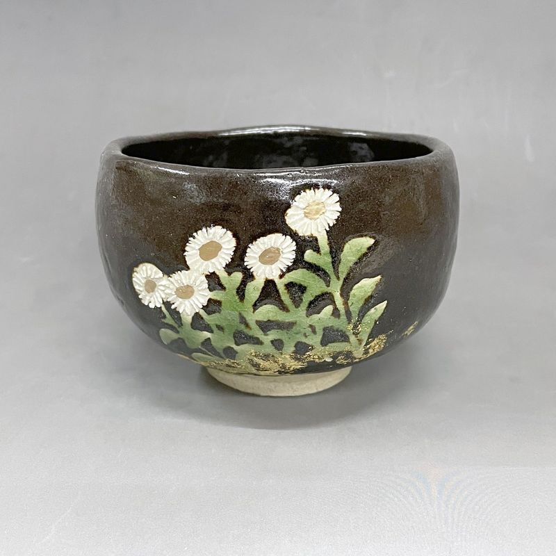 Wild Chrysanthemum: a black Raku tea bowl painted with small white chrysanthemums